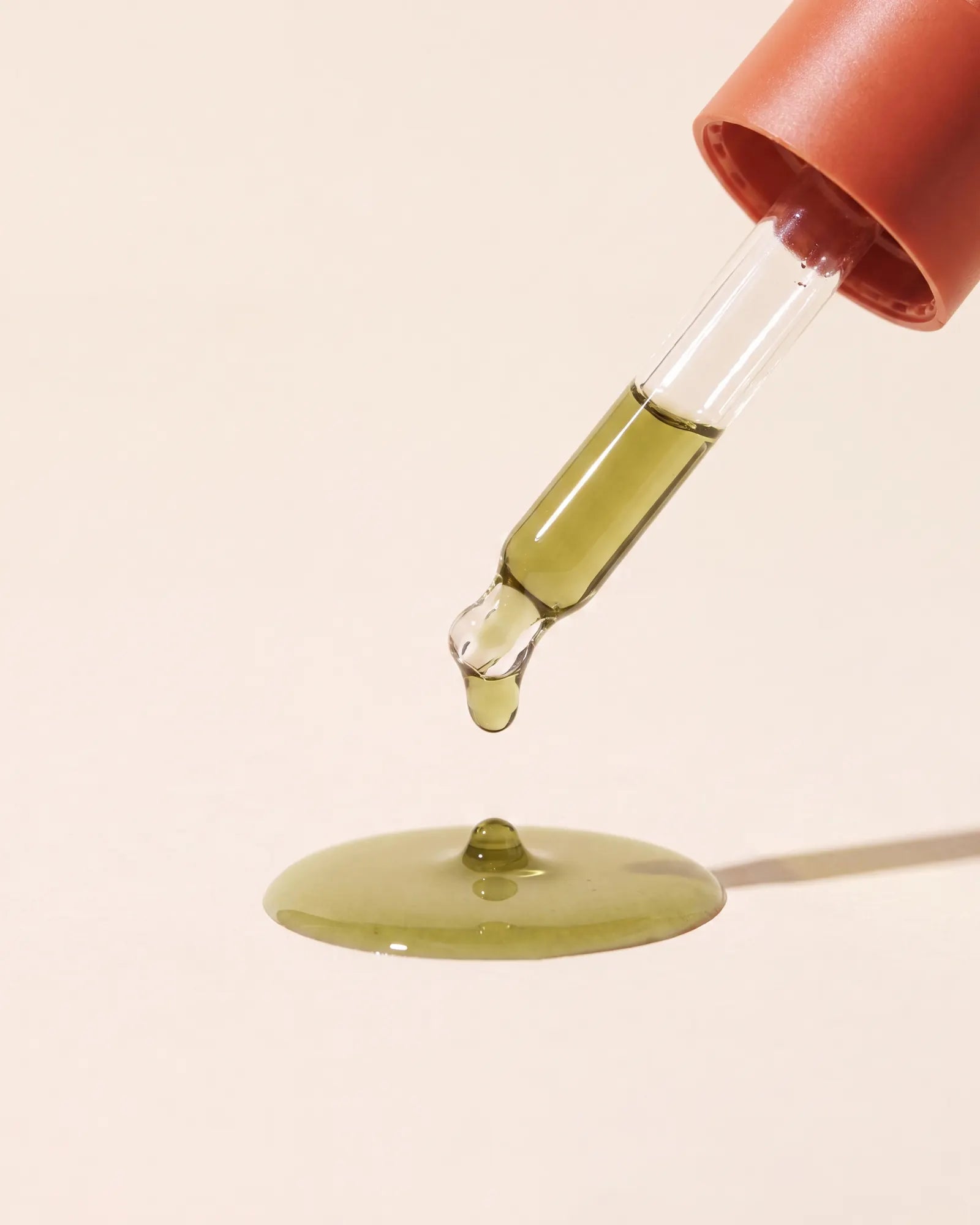 A golden oil drop suspended from the Afghani Oil dropper