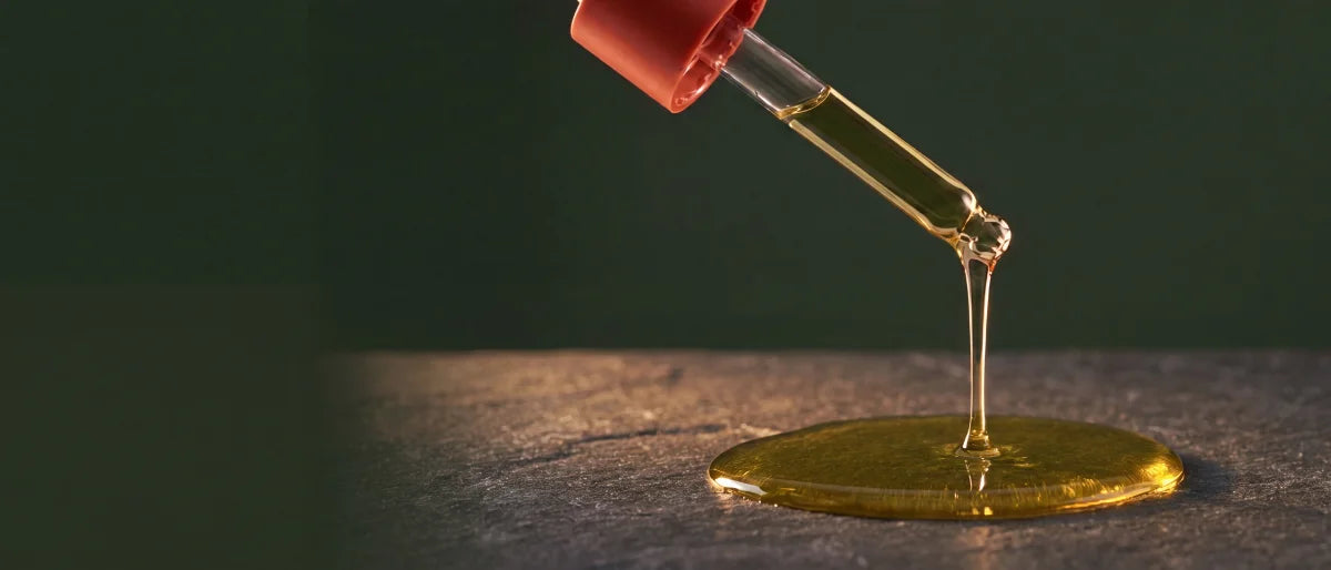 Honey-green Afghani Hair Oil on a glass dropper
