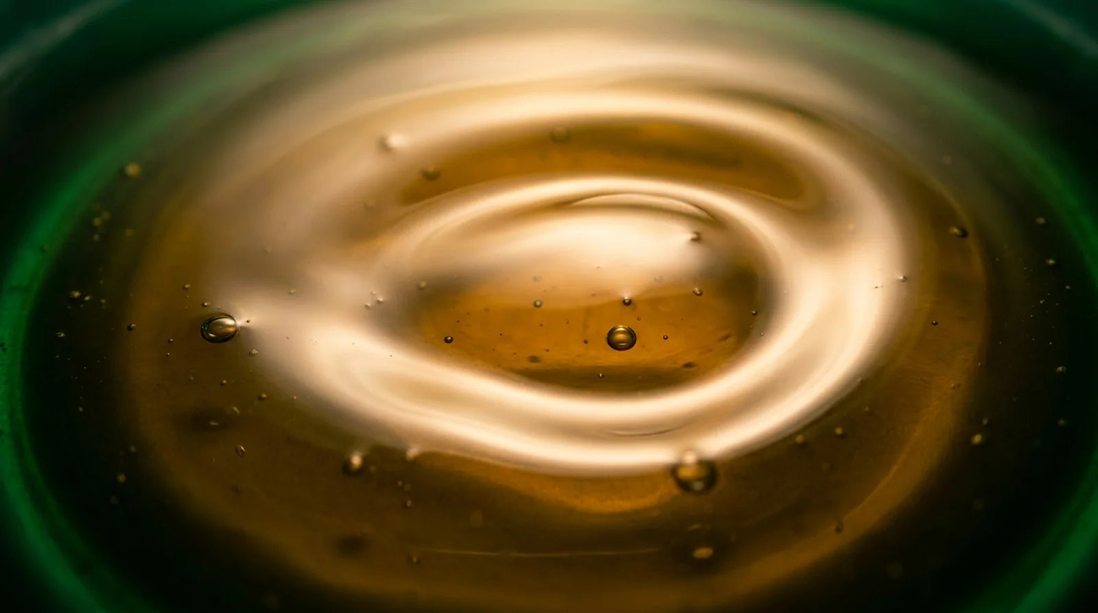 Honey-green Afghani Hair Oil on a glass dropper